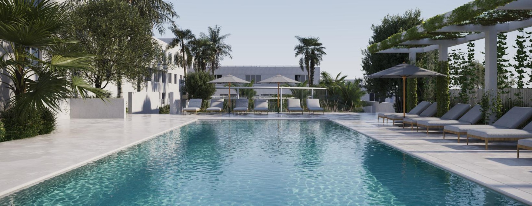 a pool with lounge chairs and umbrellas by a building