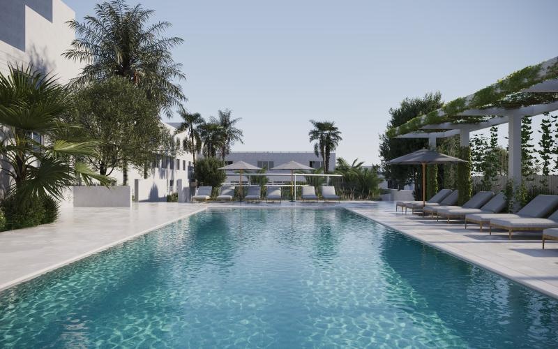 a pool with lounge chairs and umbrellas by a building