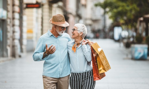 man and woman walk through town